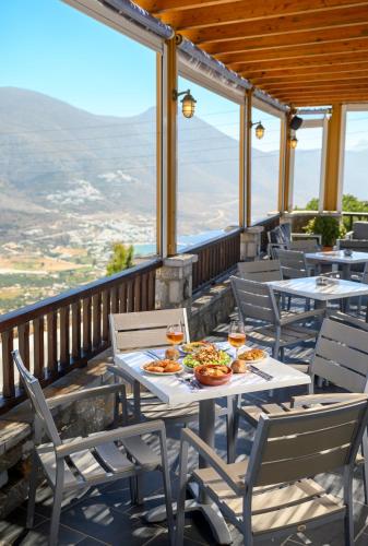 a table with food and drinks on a balcony at Vigla Hotel in Aegiali