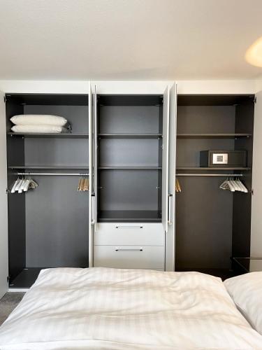 a bedroom with black shelves and a white bed at Ferienwohnung am Alexbad in Bad Alexandersbad