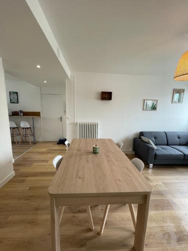 un salon avec une table en bois et un canapé dans l'établissement Le Zen - Wifi - Netflix - 3 chambres - Parking, à Clermont-Ferrand