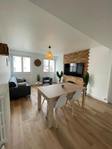 a living room with a table and a couch at Le Zen - Wifi - Netflix - 3 chambres - Parking in Clermont-Ferrand