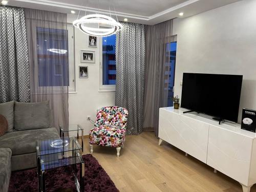 a living room with a tv and a couch and a chair at Srnina kuća in Koran