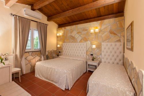 a bedroom with two beds and a stone wall at Fattoria Maremmana in Marina di Grosseto