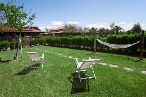 two chairs and a hammock in a yard at Fattoria Maremmana in Marina di Grosseto