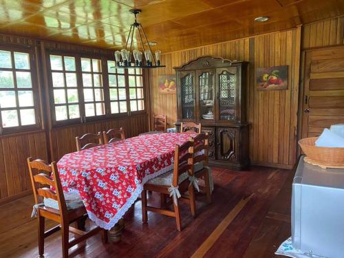 ein Esszimmer mit einem Tisch, Stühlen und einem Kronleuchter in der Unterkunft Los Alessandria in Cerro Punta