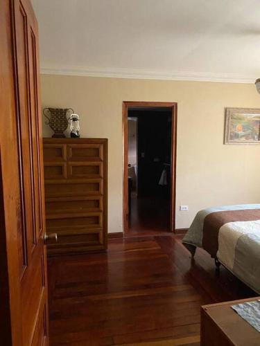 a bedroom with a bed and a dresser and a door at Los Alessandria in Cerro Punta