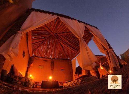 a close up of a building with an umbrella at Auberge Kasbah Dar Sahara Tours in Mhamid