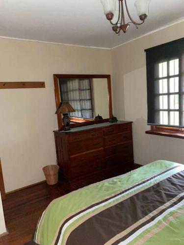 a bedroom with a bed and a dresser and a mirror at Los Alessandria in Cerro Punta