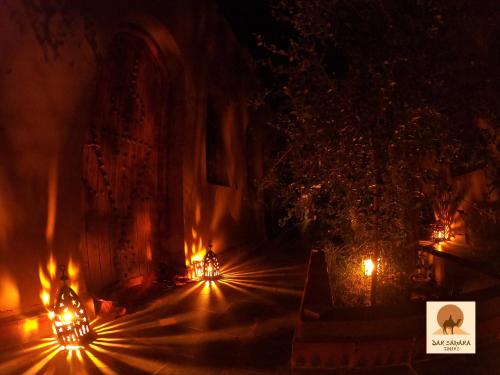 a fire tunnel with lights on a street at night at Auberge Kasbah Dar Sahara Tours in Mhamid