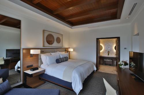 a bedroom with a large bed and a living room at Real Intercontinental Metrocentro Managua by IHG in Managua