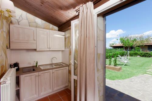 a kitchen with a view of a garden at Fattoria Maremmana in Marina di Grosseto