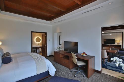 a hotel room with a bed and a desk and a television at Real Intercontinental Metrocentro Managua by IHG in Managua