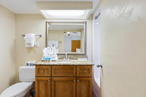 a bathroom with a sink and a toilet and a mirror at Stunning Condos Near French Quarter in New Orleans