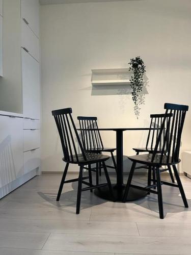 une table à manger avec trois chaises et une plante dans l'établissement Valoisa kaksio Toppilansalmessa, à Oulu