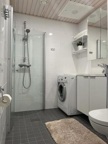 La salle de bains est pourvue d'une douche et d'un lave-linge. dans l'établissement Valoisa kaksio Toppilansalmessa, à Oulu