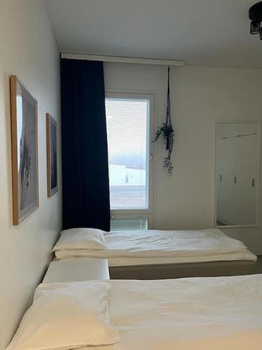- 2 lits dans une chambre avec fenêtre dans l'établissement Valoisa kaksio Toppilansalmessa, à Oulu