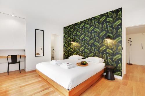 a bedroom with a large bed with a green wall at Superbe Appartement - Père Lachaise in Paris