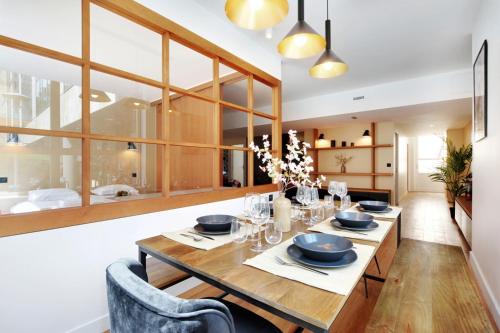 une salle à manger avec une table et des chaises en bois dans l'établissement Superbe Appartement - Père Lachaise, à Paris