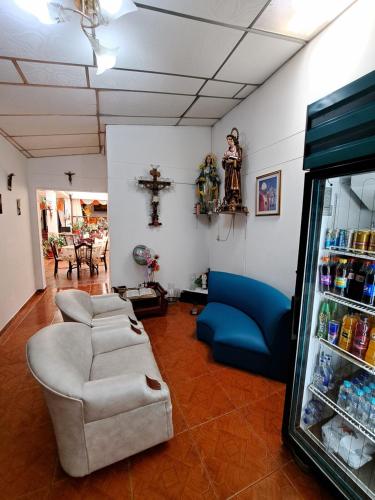 a living room with a couch and a cross on the wall at Hotel Mi Casita Pereira in Pereira