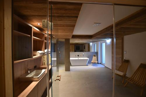 un bagno con un lavandino e una vasca in una stanza di Tanners Chalet Apartments a Altenmarkt im Pongau