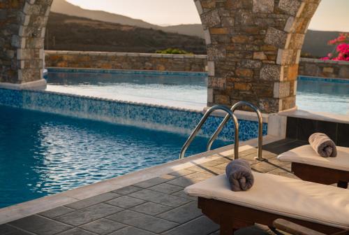 a swimming pool next to a building with a swimming pool at Vigla Hotel in Aegiali