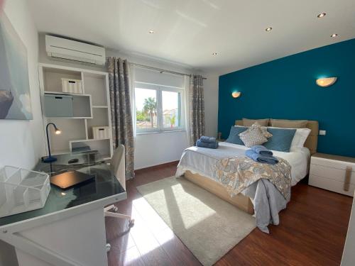 um quarto com uma cama e uma parede azul em Villa Harvey em Albufeira