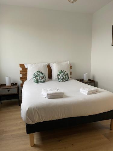 - une chambre avec un lit et 2 serviettes dans l'établissement Le Zen - Wifi - Netflix - 3 chambres - Parking, à Clermont-Ferrand