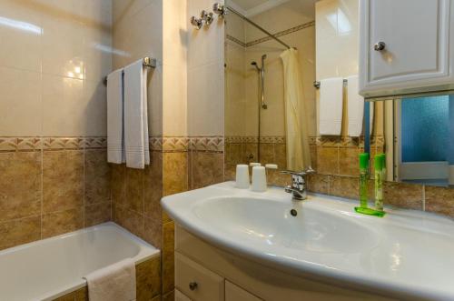 里斯本的住宿－佛拉明哥酒店，一间带水槽、浴缸和镜子的浴室