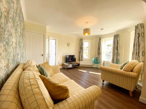 a living room with a couch and two chairs at Ockendon House Apartments in Torquay