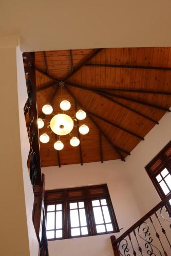 a ceiling with a chandelier in a room with windows at Kandy City Village in Kandy