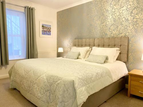 a bedroom with a large bed and a window at Ockendon House Apartments in Torquay