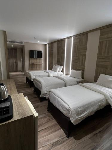 a row of four beds in a hotel room at Mass Boutique hotel in Aqaba