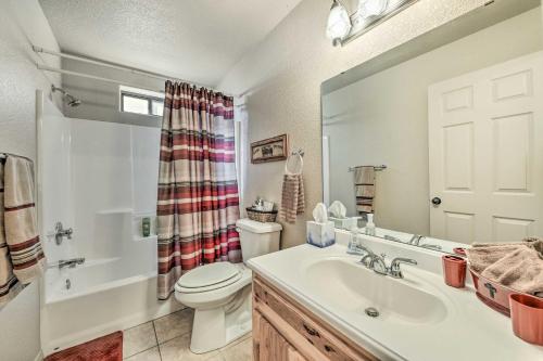 a bathroom with a sink and a toilet and a mirror at Charming Ruidoso Home with Deck and Lovely Views! in Ruidoso