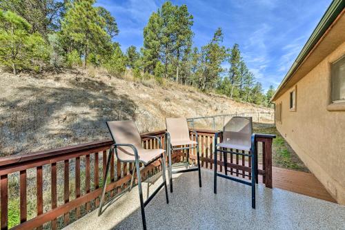 a porch with three chairs and a table at Charming Ruidoso Home with Deck and Lovely Views! in Ruidoso