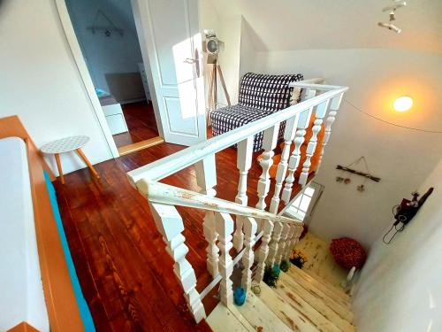 a white staircase with a chair in a room at Honey hill apartment Fruska Gora in Čerević
