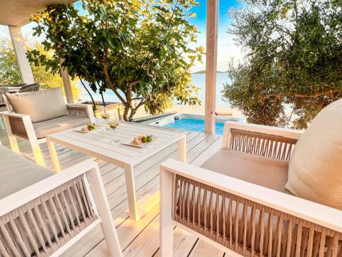 a patio with a table and chairs and a swimming pool at BUQEZ ECO RESORT - Beach Villa 81 - 1st Sea Line by beach in Drage