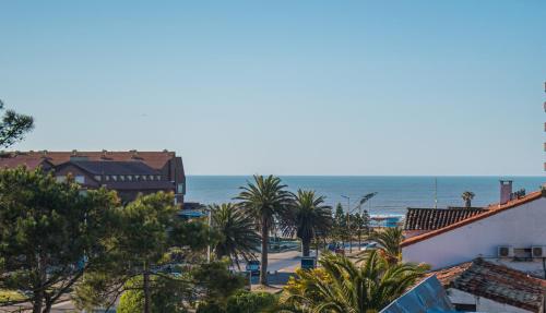 vistas a una playa con palmeras y al océano en Maitenas VIP en Pinamar