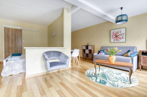 ein Wohnzimmer mit einem Sofa und einem Tisch in der Unterkunft Charmant T1 Bis Idéalement situé au pied des thermes Amélie-les-bains in Amélie-les-Bains-Palalda