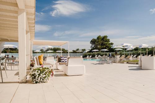 a patio with lounge chairs and a swimming pool at Piccolo Hotel - Adults Only in Porto Ottiolu