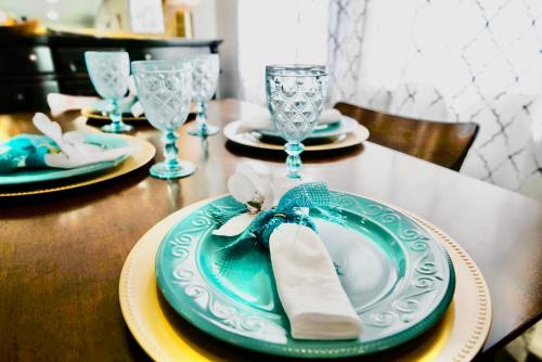 una mesa con platos azules y copas de vino. en Downtown Vintage Modern Home PNW Wineries, en Albany