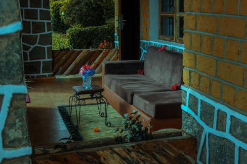 un divano su un portico con tavolo di LUSHOTO EXECUTIVE LODGE a Lushoto