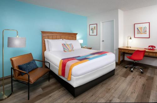 een slaapkamer met een bed, een bureau en een stoel bij The Sojourn Los Angeles - Sherman Oaks in Sherman Oaks