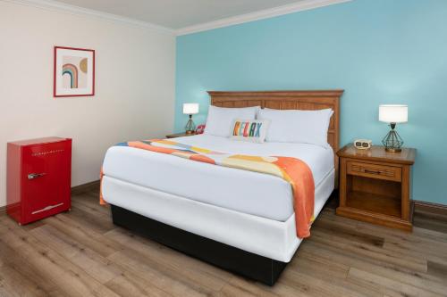 a bedroom with a large white bed and a red cabinet at The Sojourn Los Angeles - Sherman Oaks in Sherman Oaks