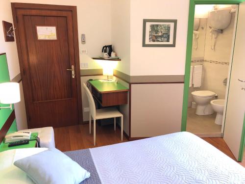 a bedroom with a bed and a desk and a toilet at Hotel Signa in Perugia