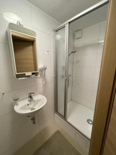 uma casa de banho com um chuveiro e um lavatório. em A&C Hotel em Backnang