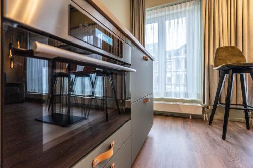 Una cocina con encimera con taburetes. en Appart hôtel En Ville en Bastogne