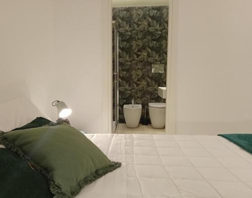 a bedroom with a bed and a bathroom with a sink at Narciso boutique apartment in Acireale