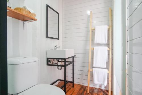 La salle de bains est pourvue de toilettes blanches et d'un lavabo. dans l'établissement Container Smart Stay CSS, à Bedugul