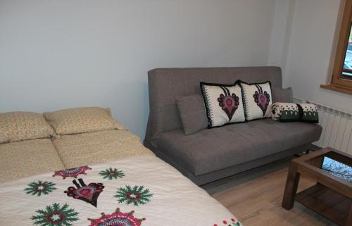 a living room with a bed and a couch at Apartament Kaspruś in Zakopane
