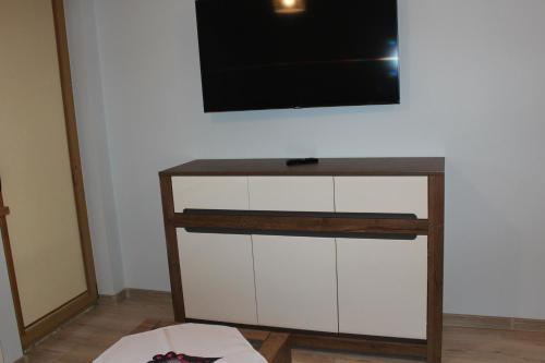uma televisão de ecrã plano em cima de um armário branco em Apartament Kaspruś em Zakopane