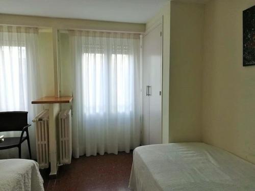 a bedroom with two beds and a door with curtains at Apartamento Lina, a 20 metros de la playa in Lloret de Mar